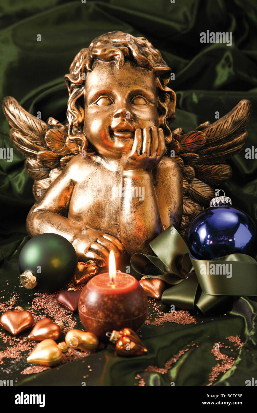 Still life on a green cloth, gold angel, candle, Christmas tree balls