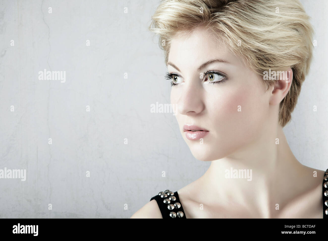 Portrait of a young blond woman in front of a white wall Stock Photo ...