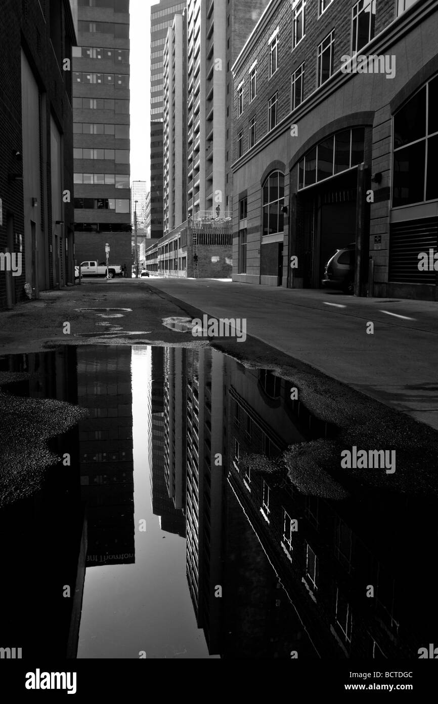 A city's buildings reflected in a puddle. Stock Photo