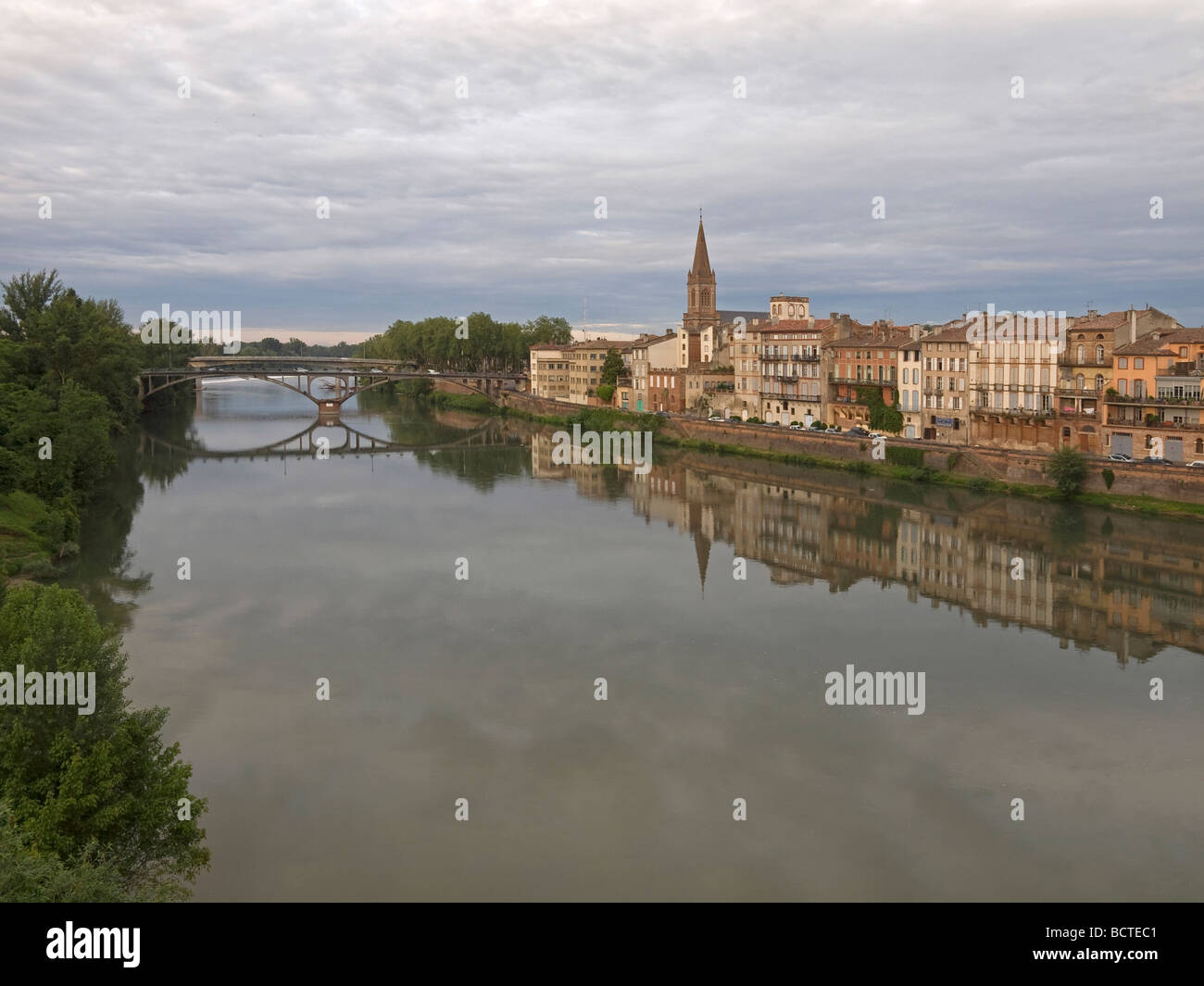 river Tarn with light reflection of houses at the bank in background the old bridge in Montauban in France Stock Photo