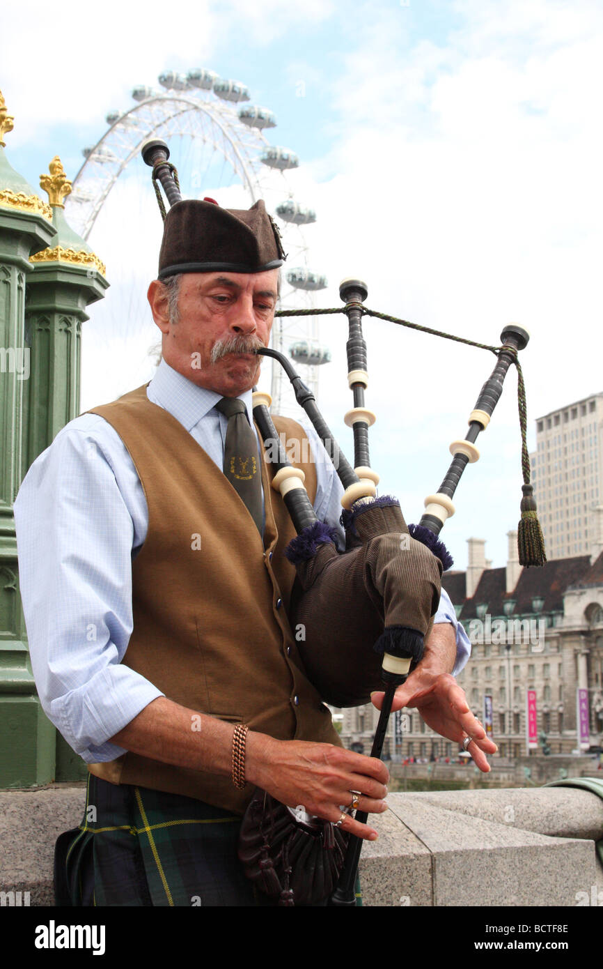 A street performer playing bagpipes on Westminster Bridge, London