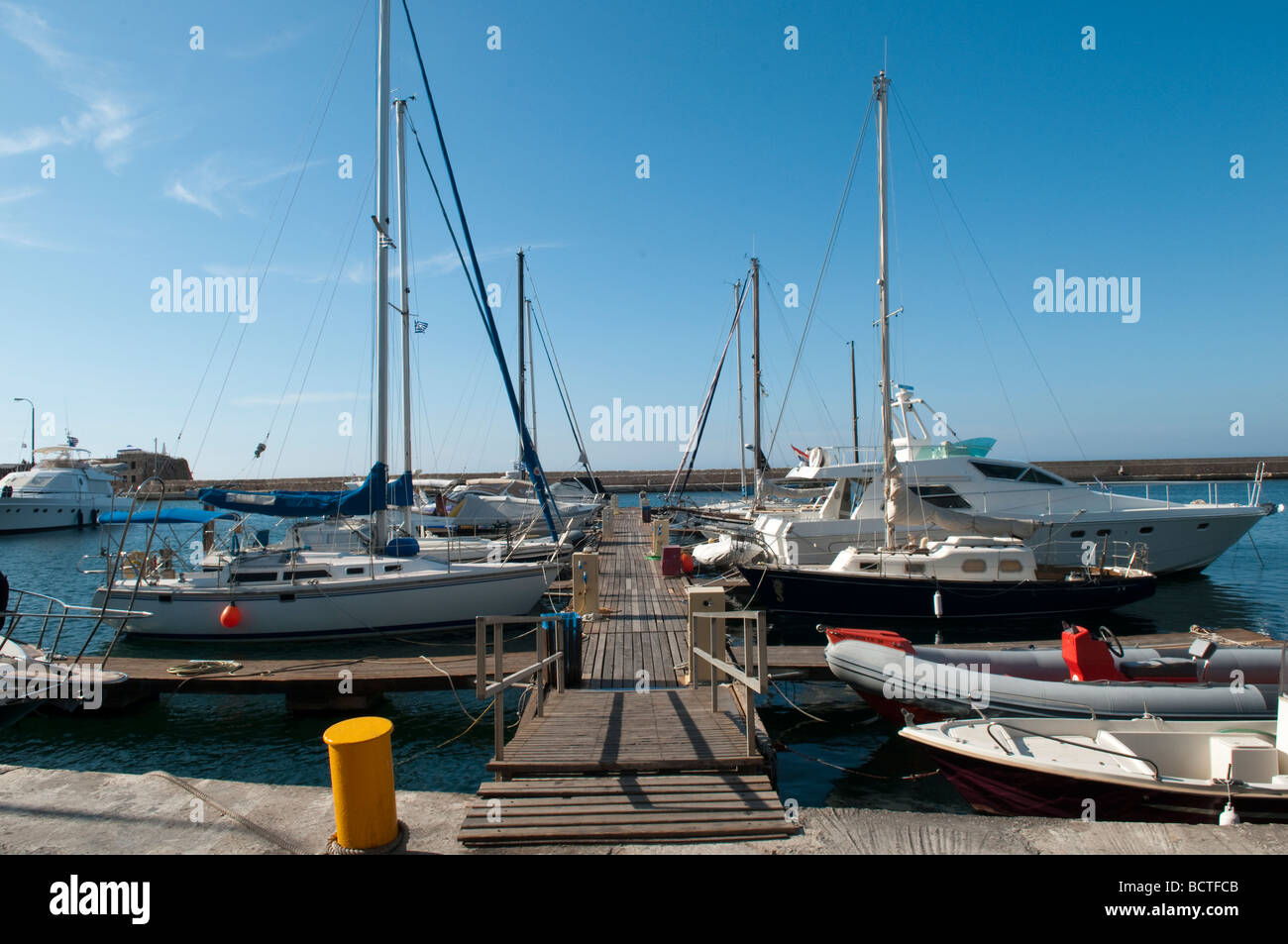 Yachts moored on the jetty at the Venetian harbour in Chania, Crete, Greece. Stock Photo