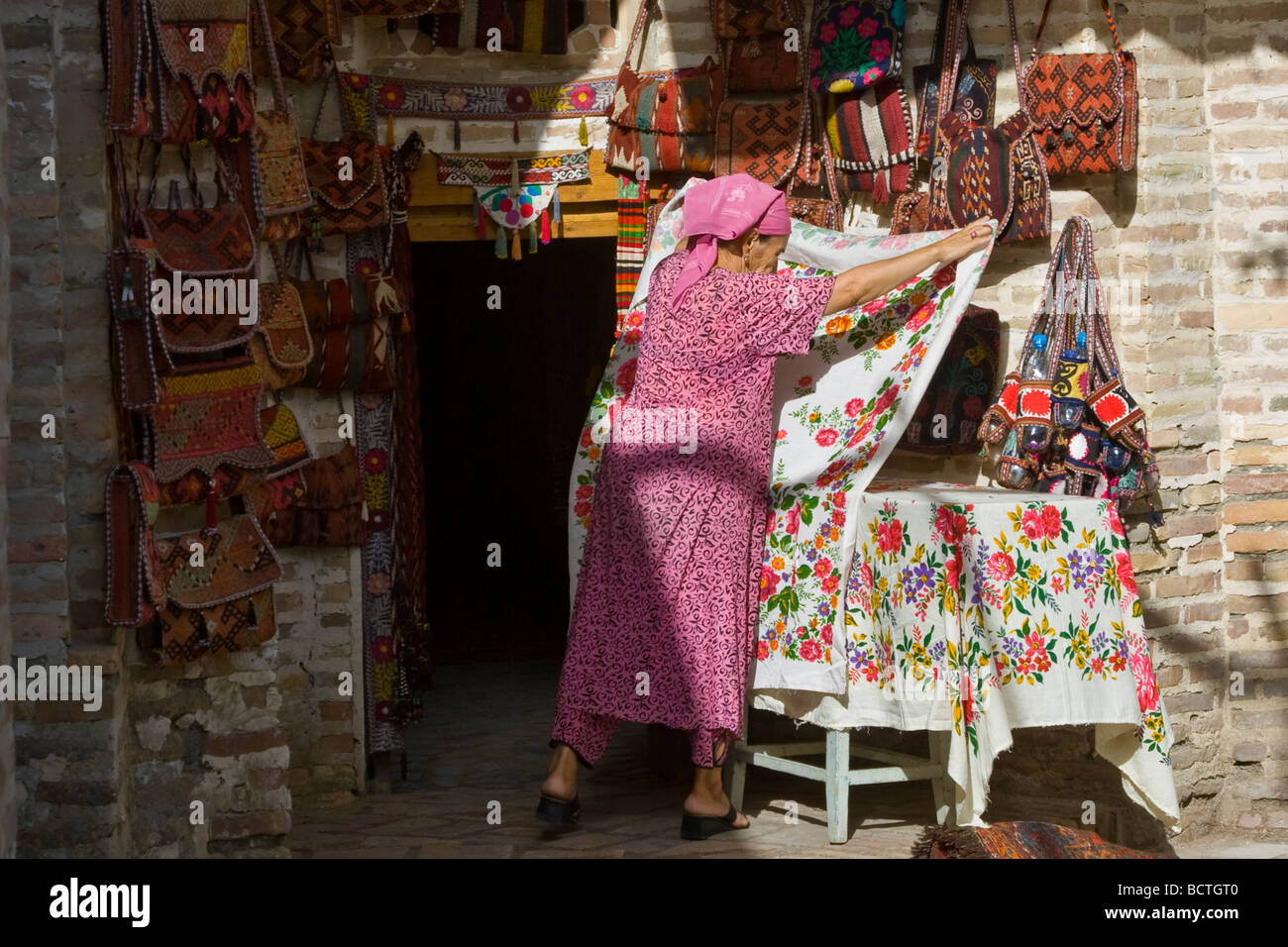 Woman Setting up Souvenir Shop in Bukhara Uzbekistan Stock Photo