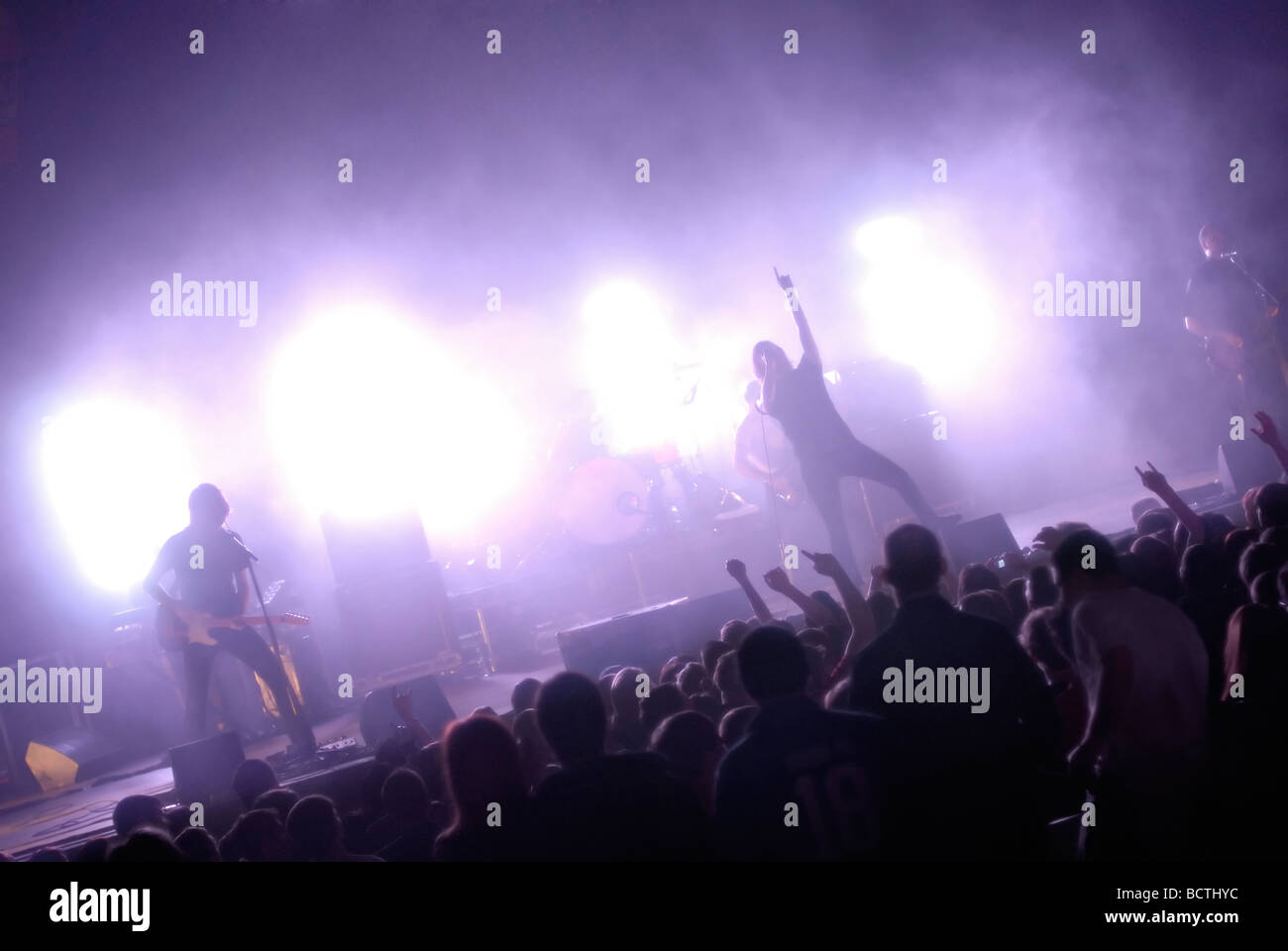 Rock band playing live on stage to audience, with colorful lighting; generic or anonymous concept image Stock Photo