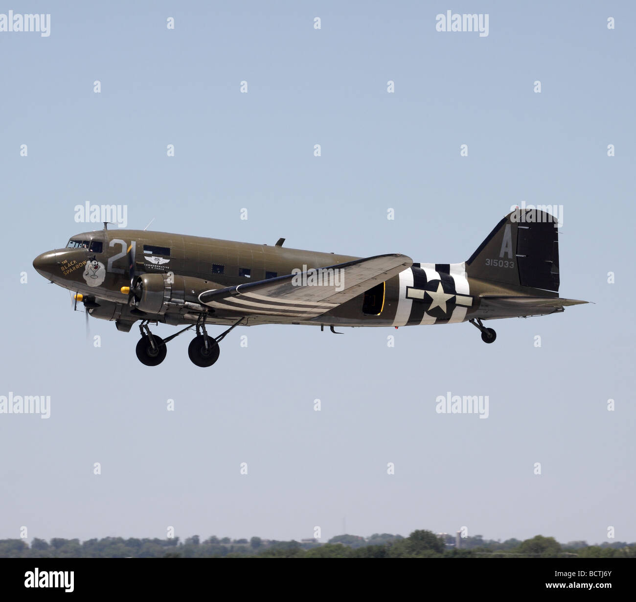 A Douglas C-47 warbird peforms a fly-by at an air show in Janesville, Wisconsin.  This plane is operated by the Commemorative Air Force. Stock Photo
