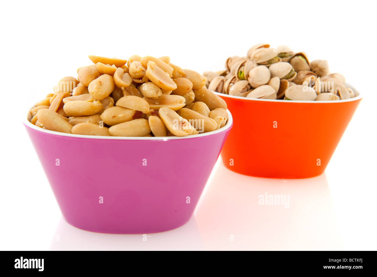 pistachio and peanuts in colorful bowls Stock Photo Alamy