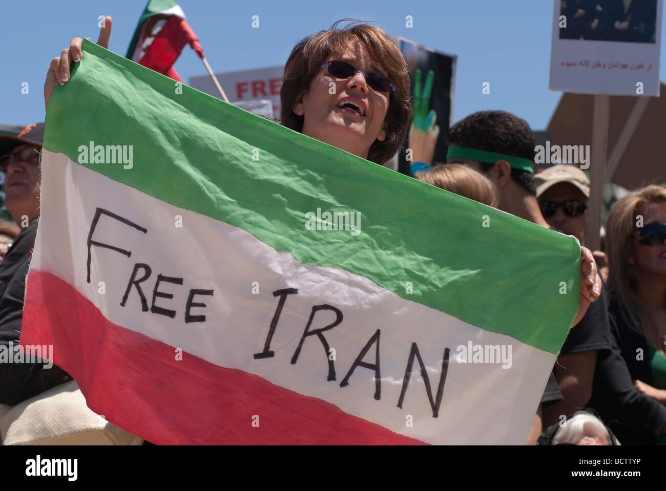 An Iranian woman holds an Iranian Flag with 'Free Iran' written across it during a demonstration in San Francisco, CA. Stock Photo