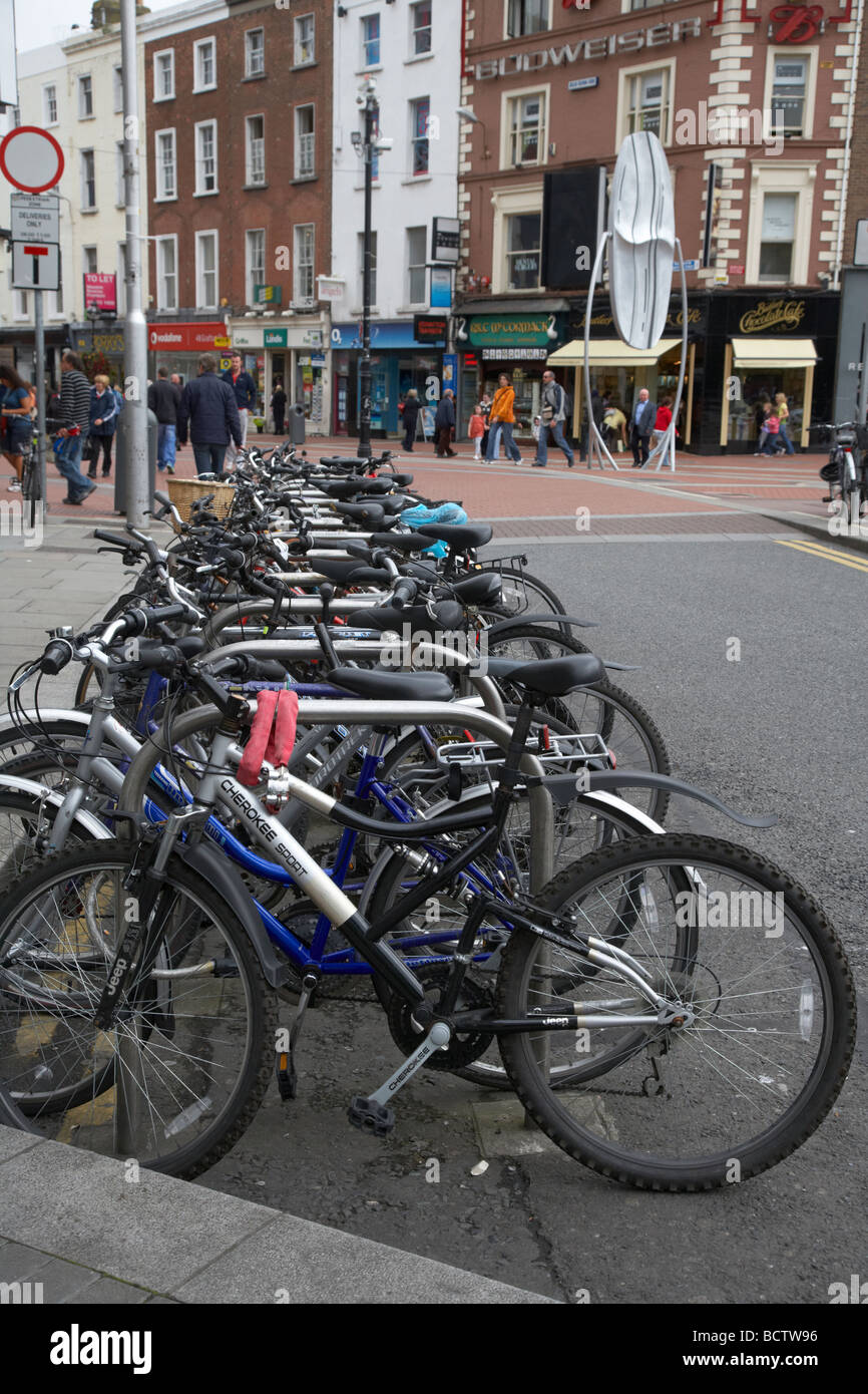 row of bicycles in a bike park at the top of grafton street in dublin republic of ireland Stock Photo