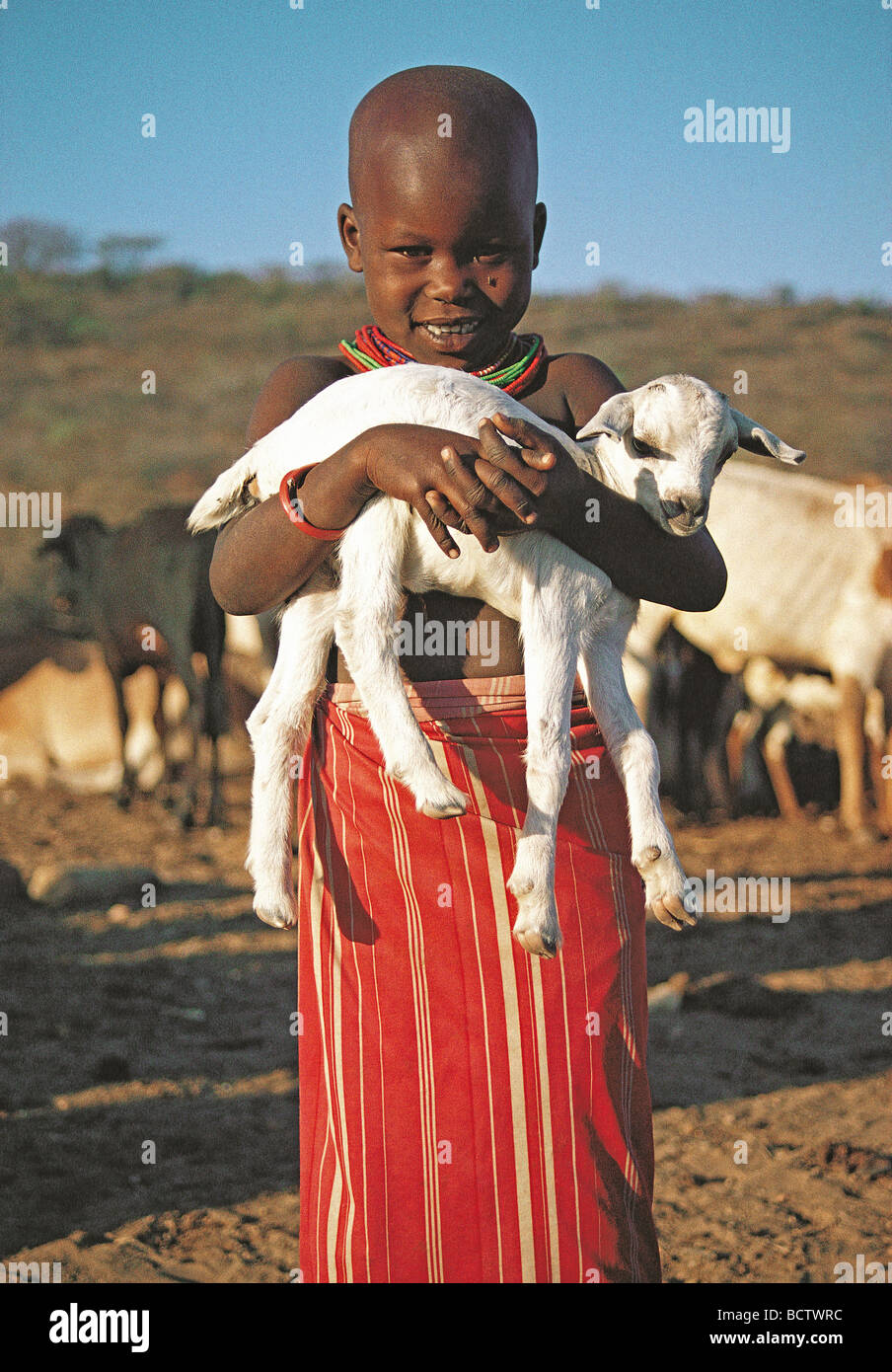 Young Samburu girl with a big smile holding a baby Goat near Samburu National Reserve Kenya East Africa Stock Photo