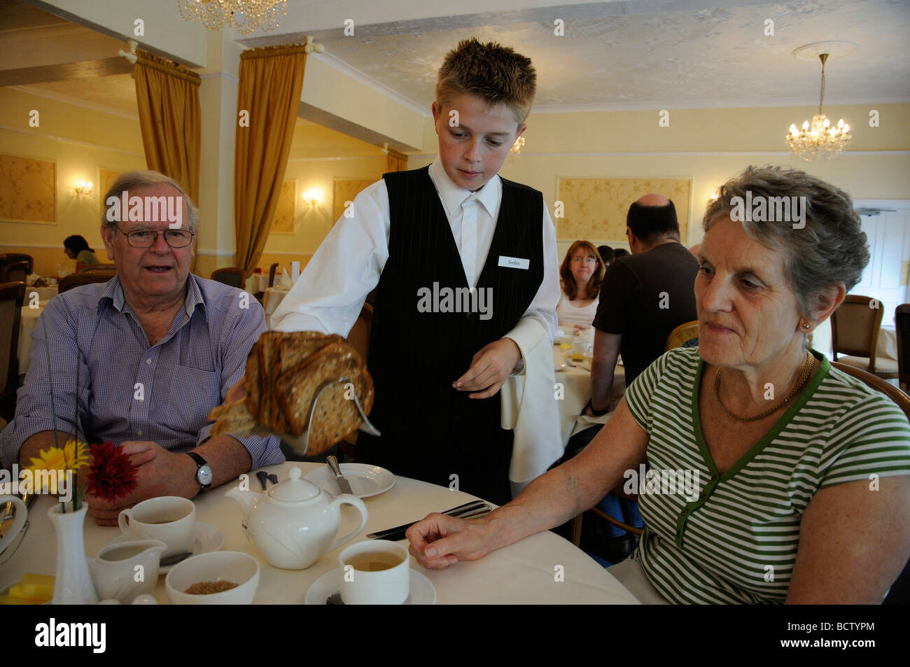 Work experience student serving breakfast in a hotel restaurant Stock Photo