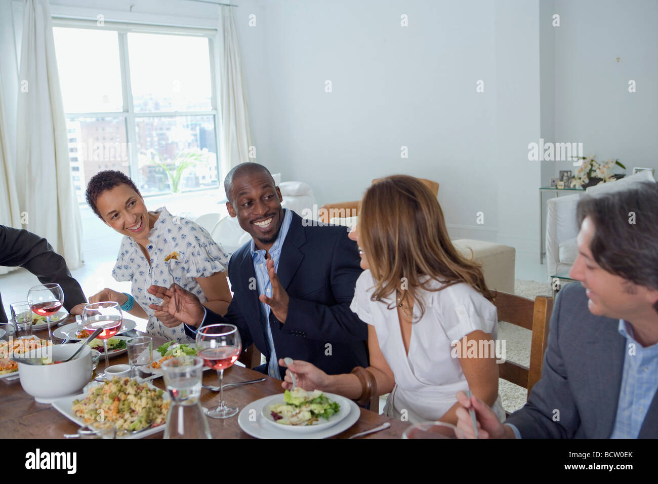 Close-up of two men and two women sitting at a dining table Stock Photo