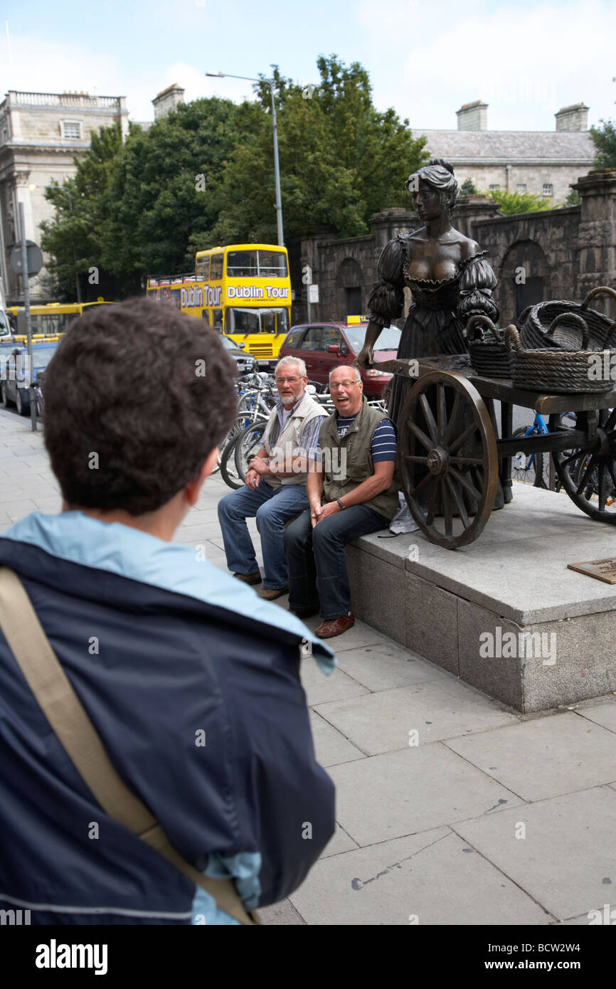 tourists having their photo taken at the molly malone statue in dublin city centre republic of ireland Stock Photo