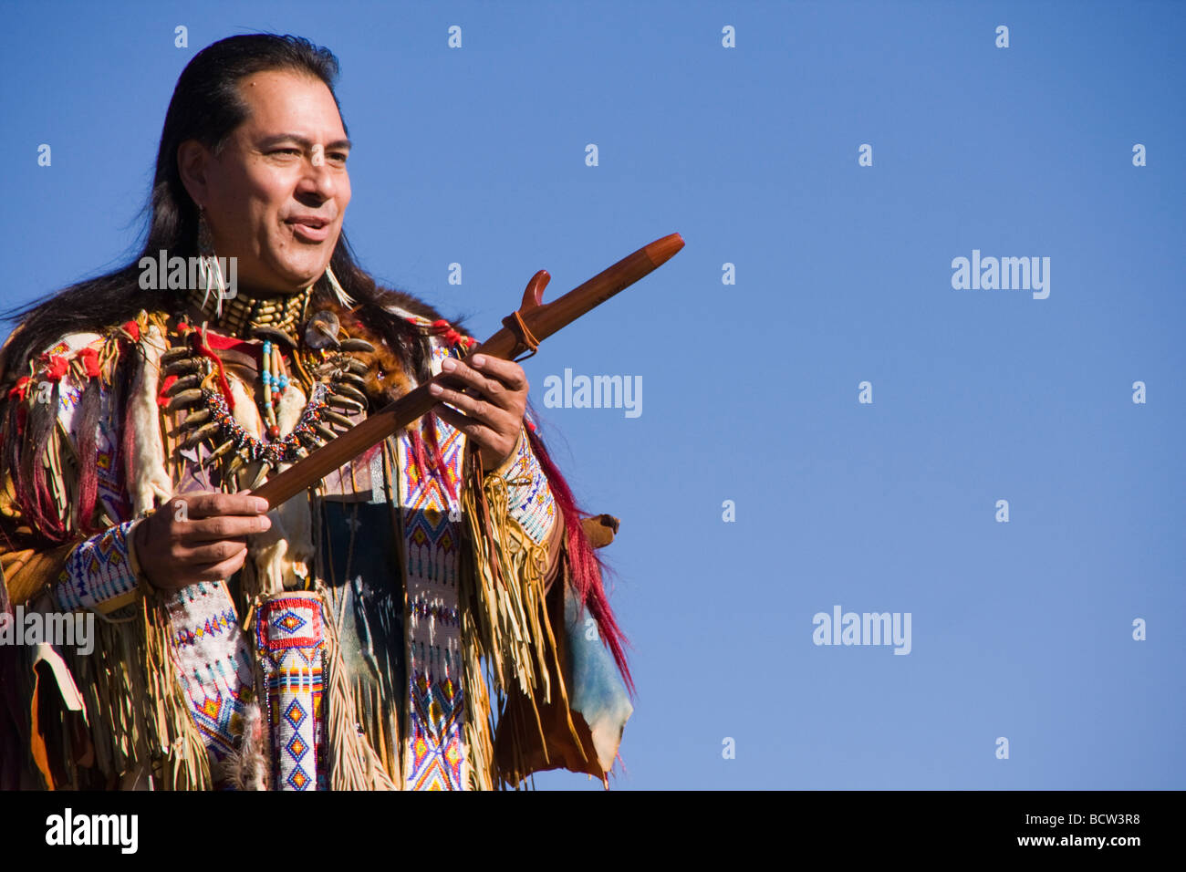 Lakota man in traditional clothing holding a flute, Donner Summit, Truckee, California, USA Stock Photo