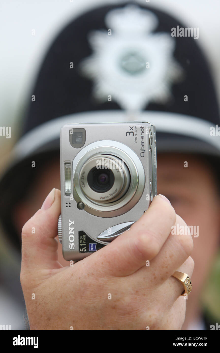 A British police officer taking a photograph on a Canon compact camera Stock Photo