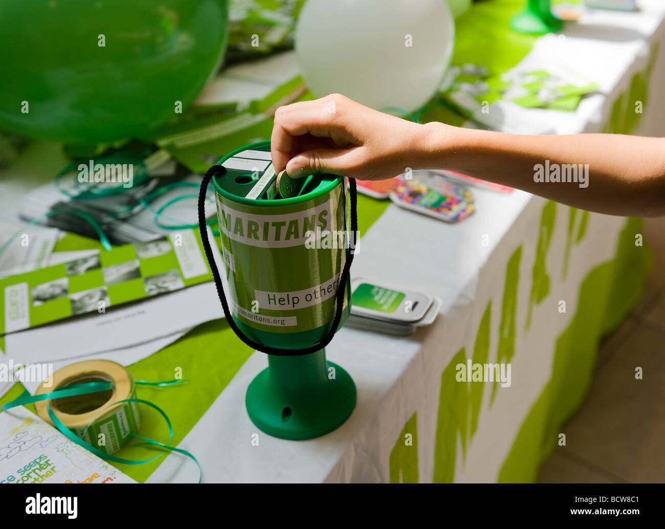 A person donating a pound coin to the Samaritans charity. Stock Photo