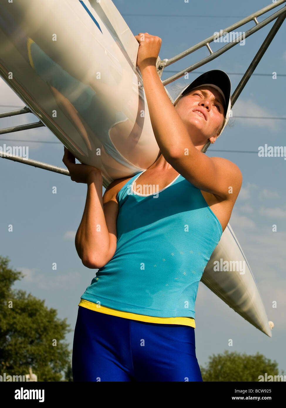 Rower girl carrying sport boat outdoors summer Stock Photo