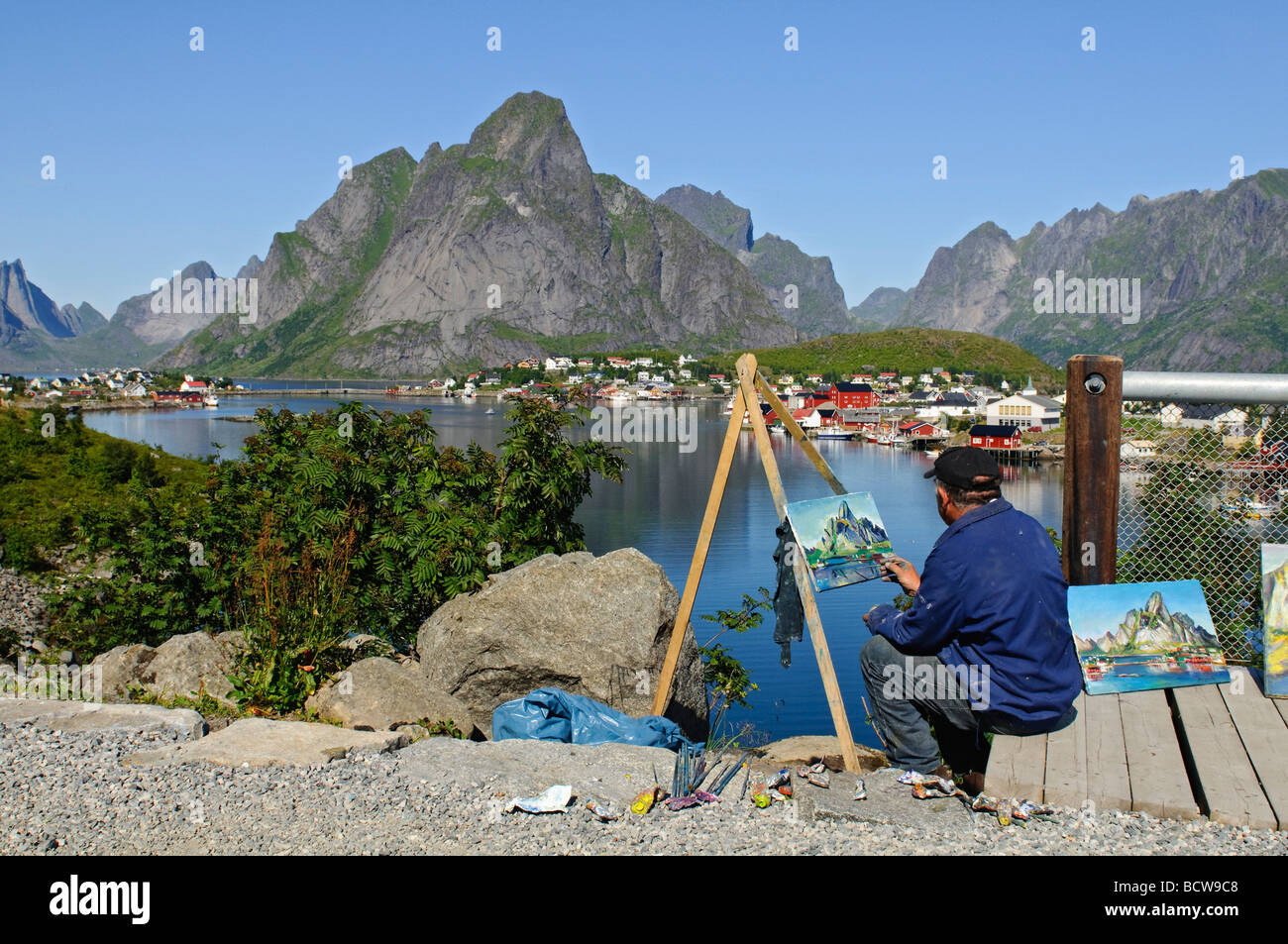 A summer day in Reine in Lofoten islands North Norway An artist paints the mountains and landscape Stock Photo