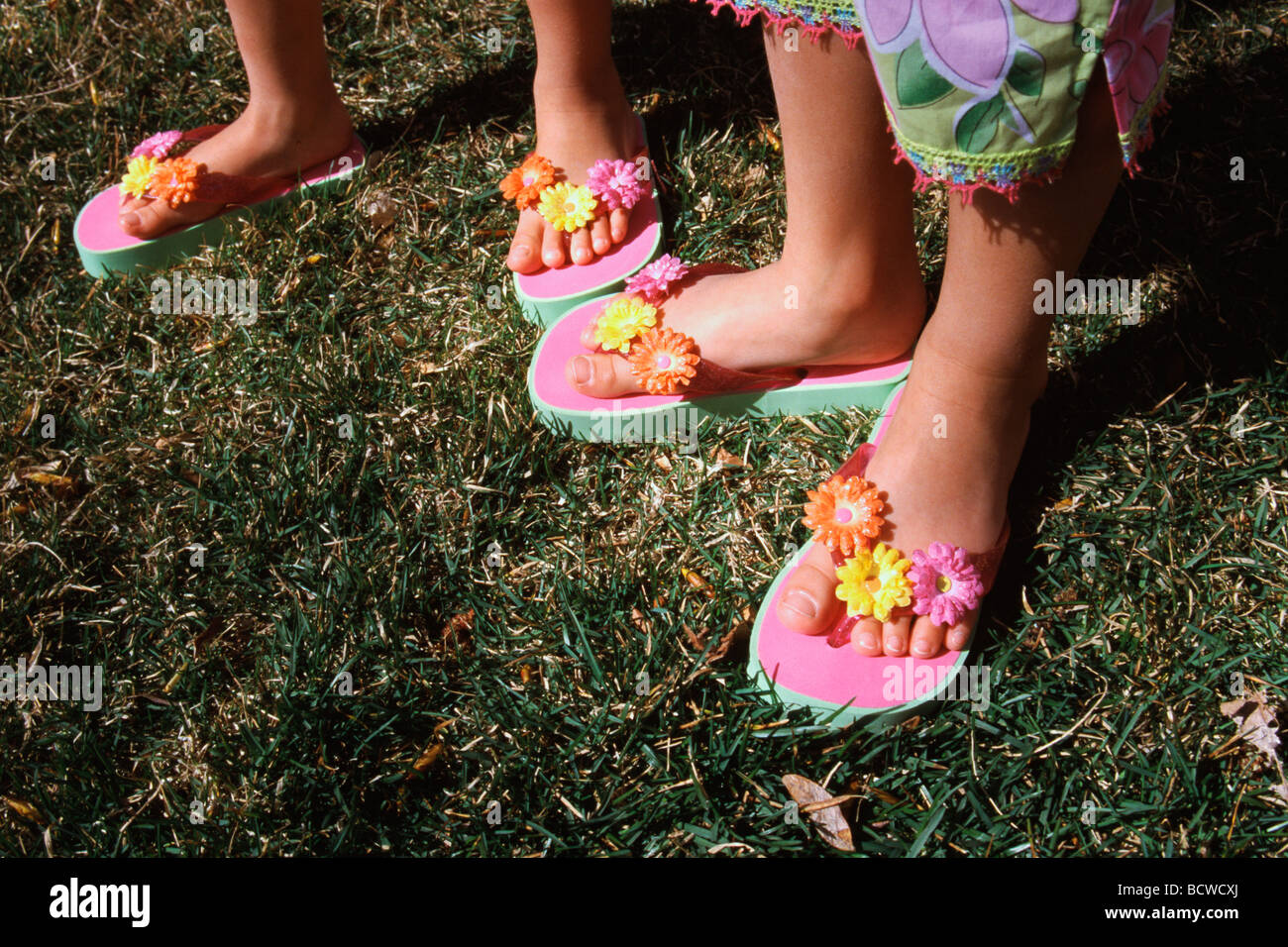 Low section view of two girls wearing flip-flops Stock Photo - Alamy