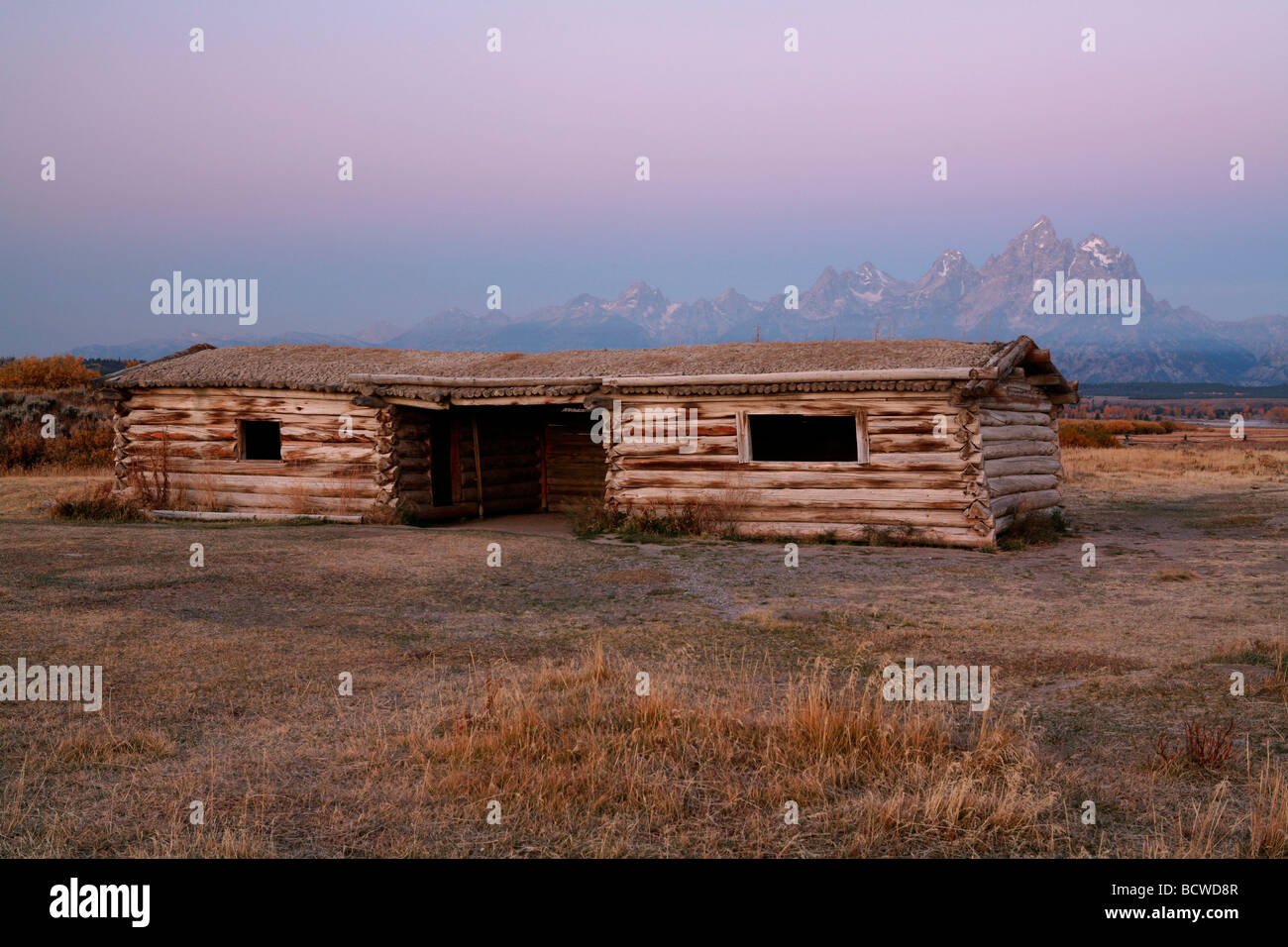 Log cabin in a field with mountains in the background, Cunningham Cabin, Grand Teton National Park, Wyoming, USA Stock Photo