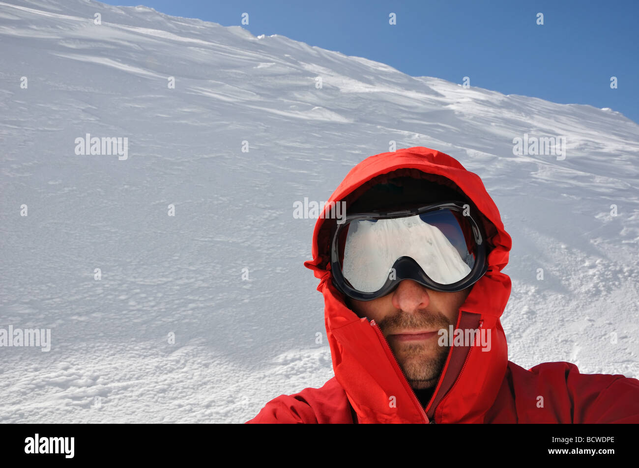 young man with goggles ready for free style ski action from the top of ...