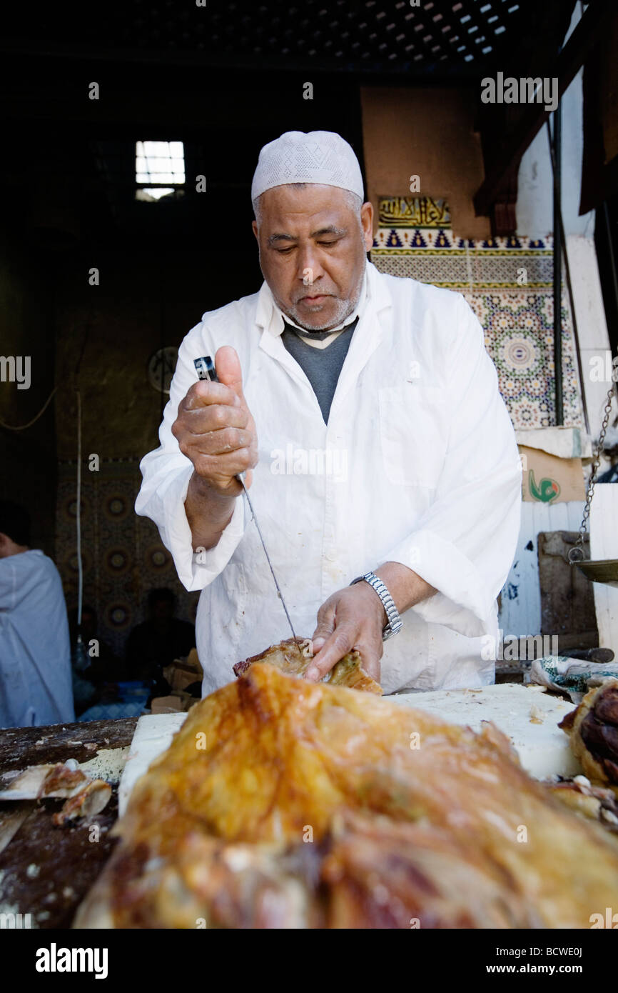 Man selling delicious lamb meat in a market alley (souk or souq) in old