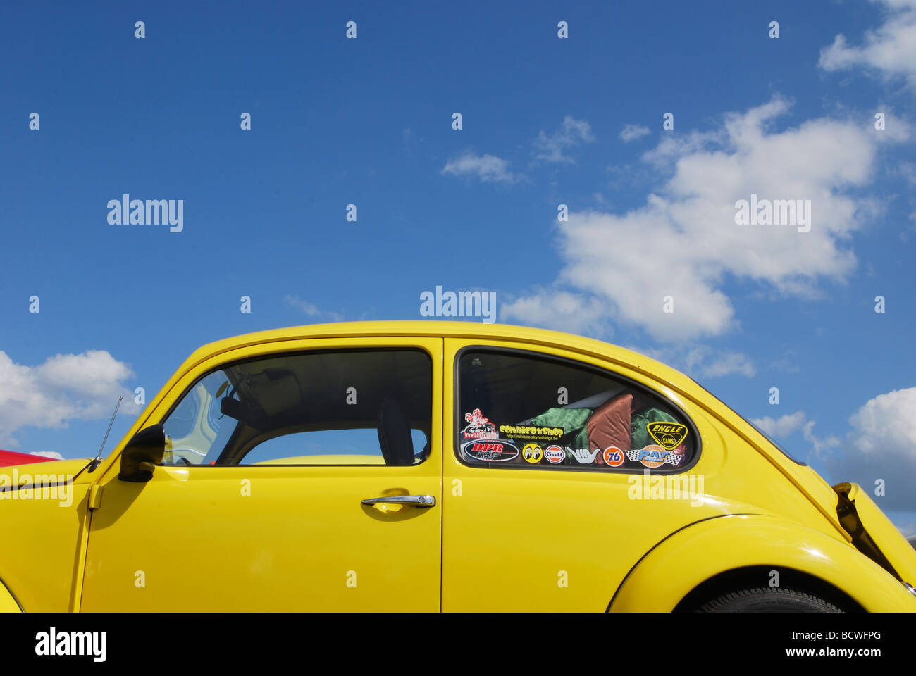 Classic yellow VW beetle against blue skies Stock Photo