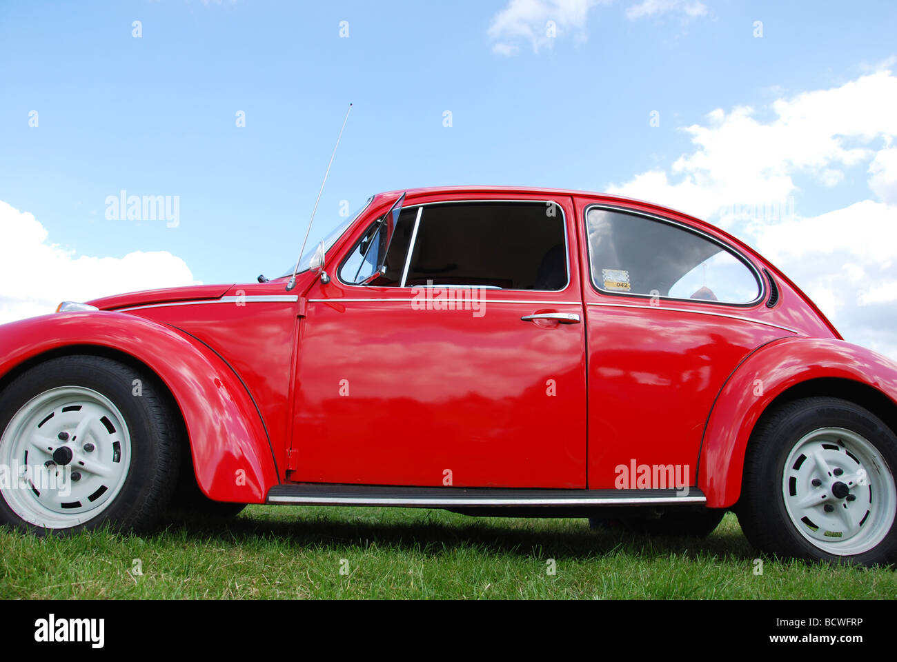 Classic red VW beetle against blue skies Stock Photo