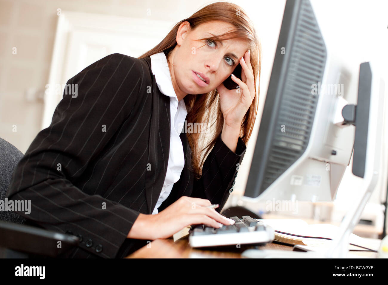 Woman stressed at computer Stock Photo