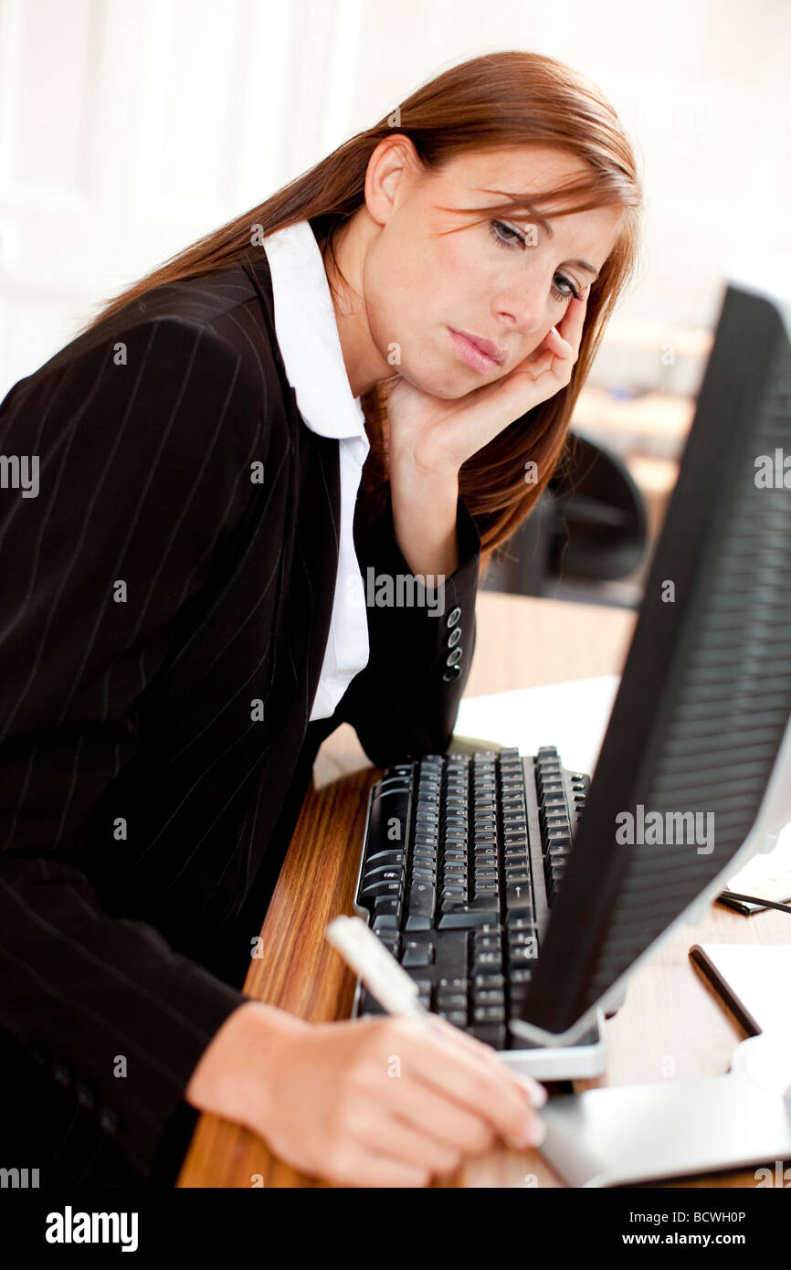 Woman stressed at computer Stock Photo