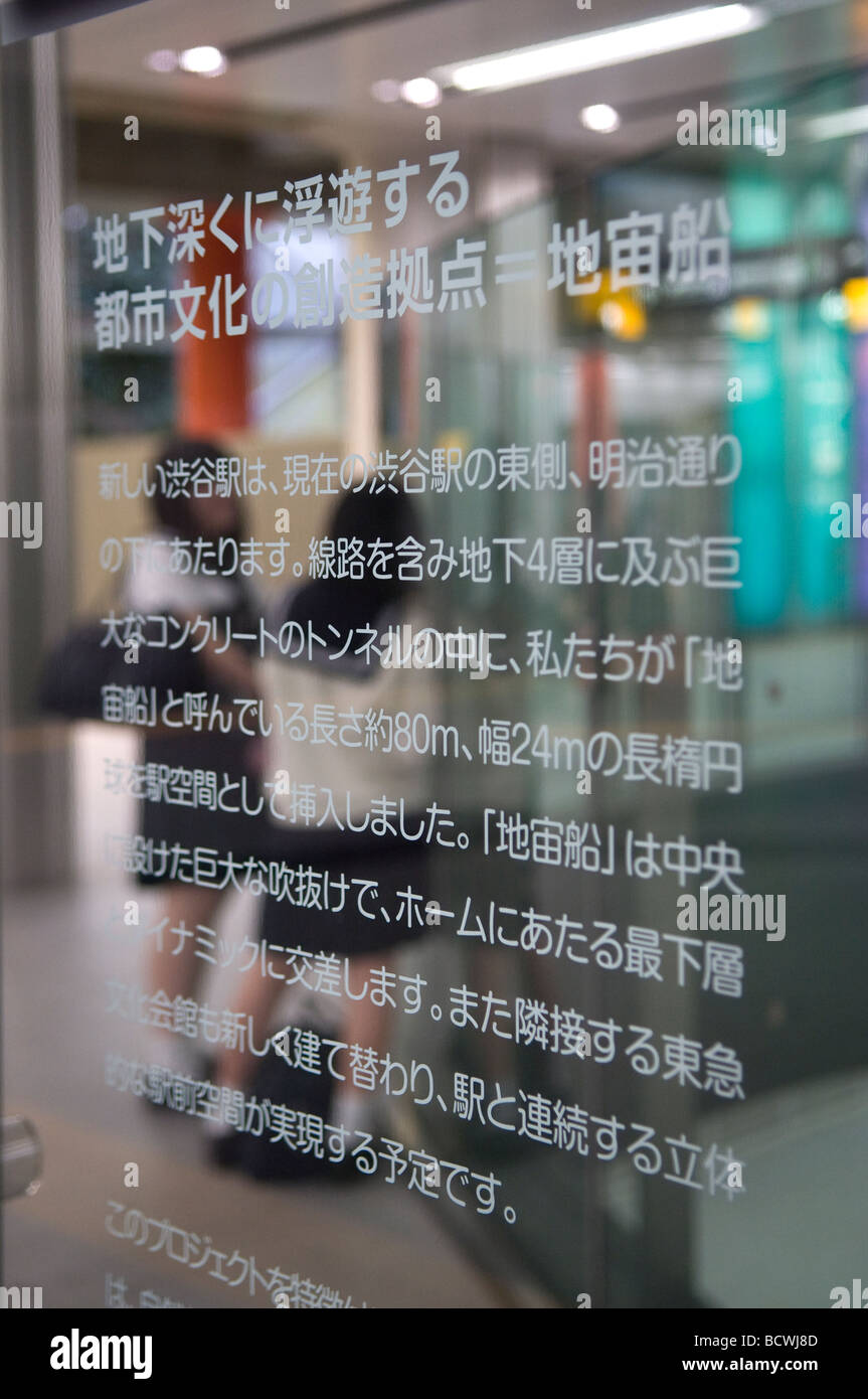 Young scholars are seen through transparent sign in a metro station Tokyo Japan Stock Photo