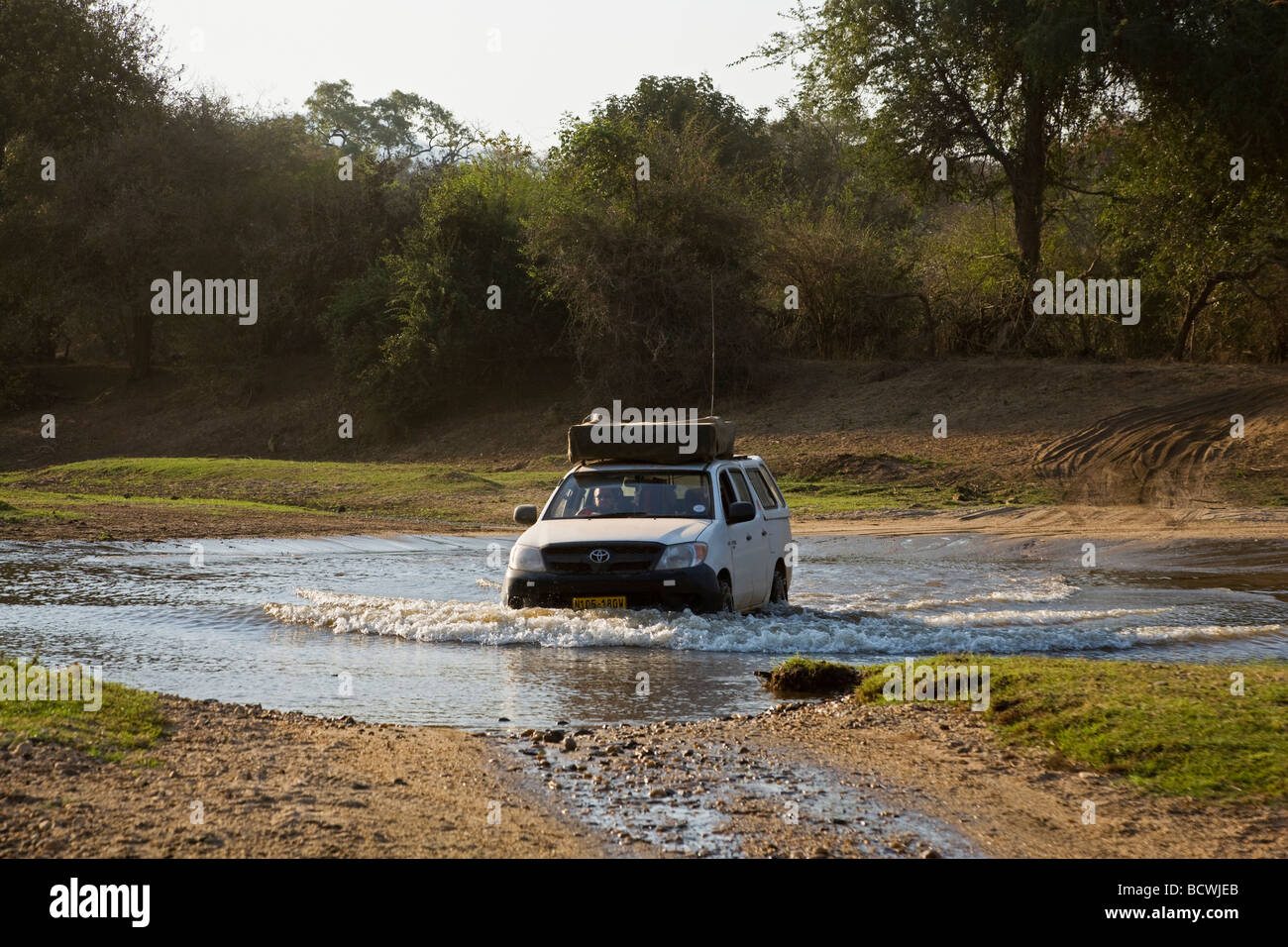 Four wheel drive driving through rivver, near Lower Zambezi National Park, Zambia, Africa Stock Photo