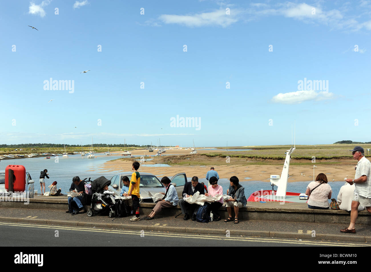 Holidaymakers eat fish and chips at Wells next the Sea holiday destination  and fishing town on the North Norfolk coast Stock Photo