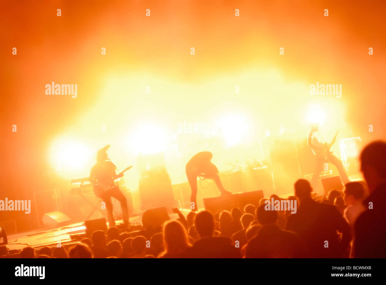 Rock band playing live on stage to audience, with colorful lighting; generic or anonymous concept image Stock Photo