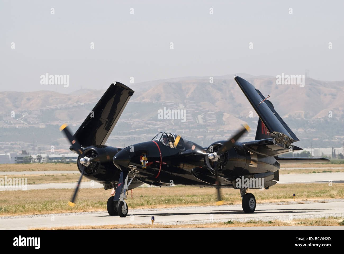 A Grumman Tigercat taxis on the runway with its wings folded up. Stock Photo