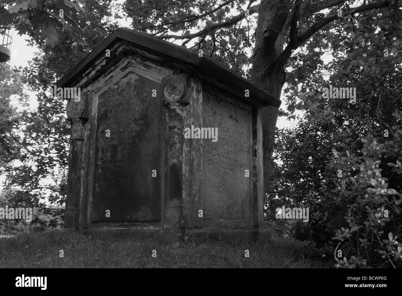 Black and white picture of a church yard vault taken from public path Stock Photo