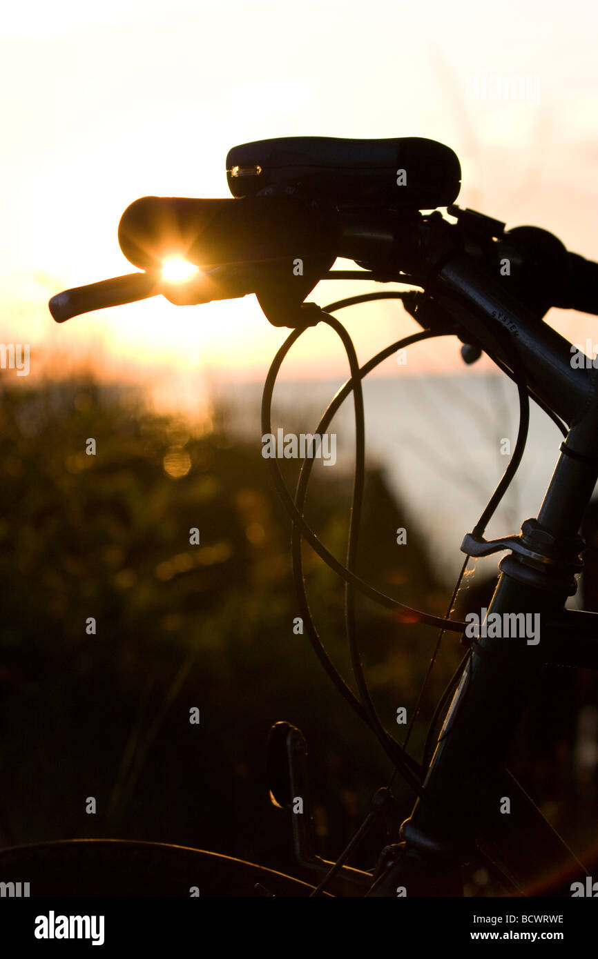 Bicycle by the water at sunset Stock Photo