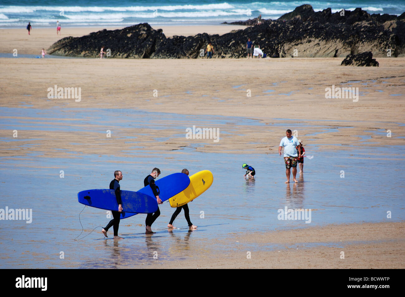 surfers carrying surfboards on fistral beach,cornwall,uk Stock Photo
