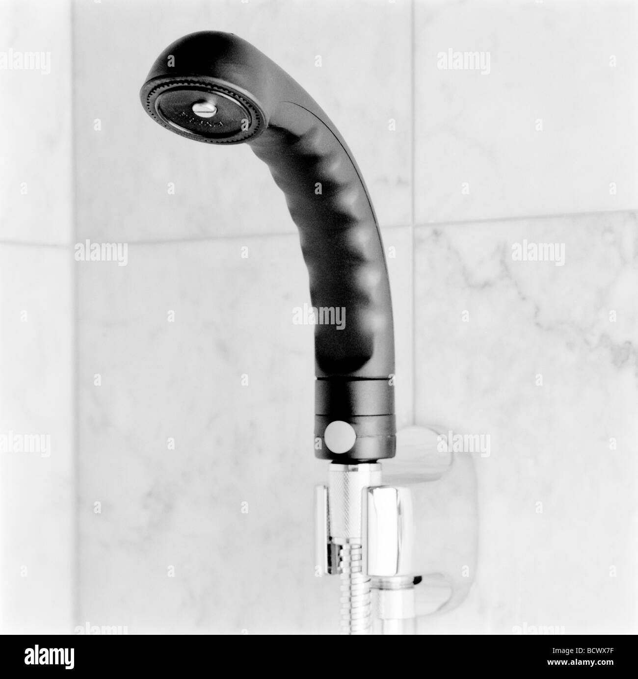 https://c8.alamy.com/comp/BCWX7F/a-black-handheld-showerhead-hanging-in-a-chrome-fixture-on-a-white-BCWX7F.jpg