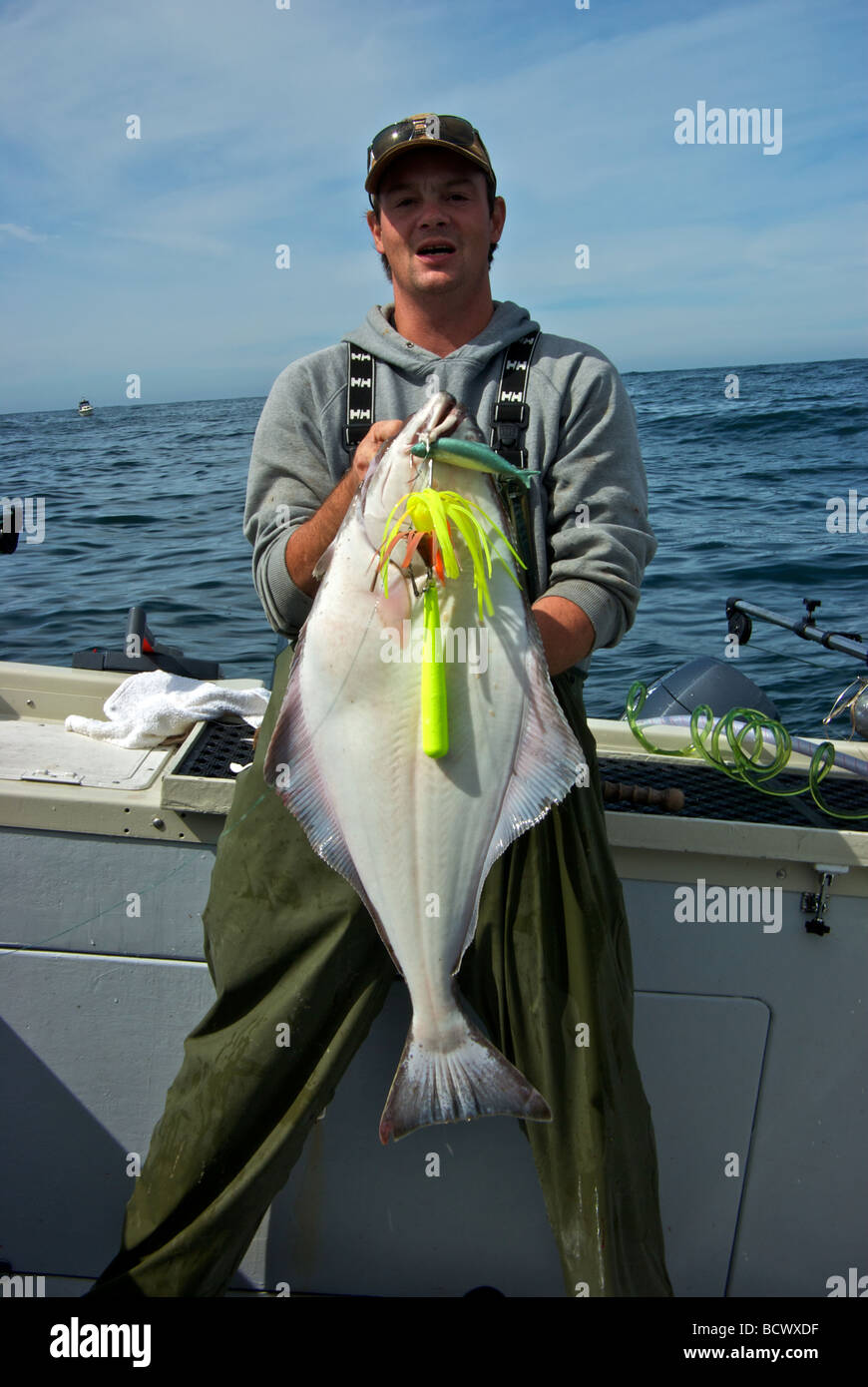 Fishing guide holding chicken halibut sport bottom fish from