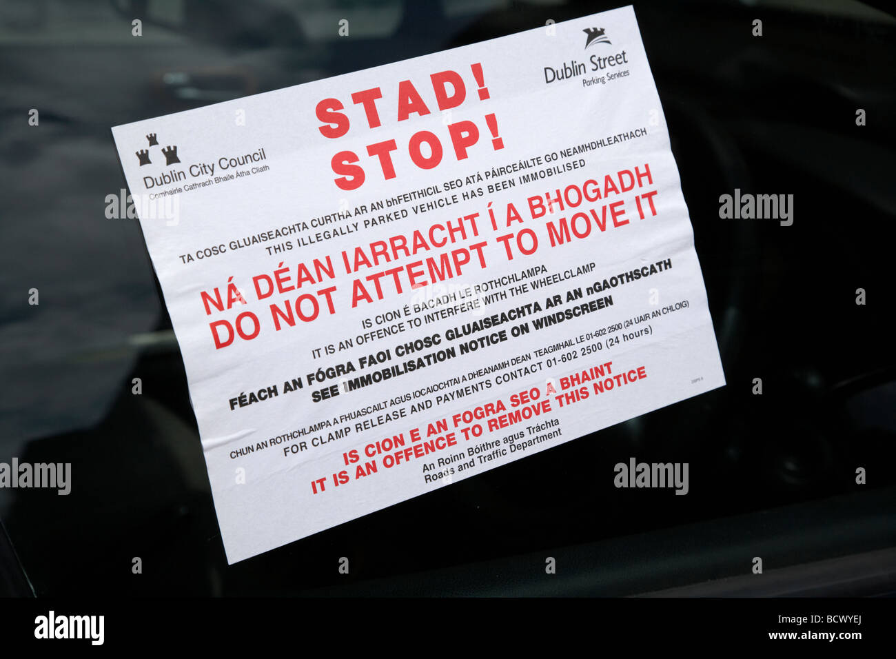 bilingual stop notice for car clamped with wheelclamp in dublin city