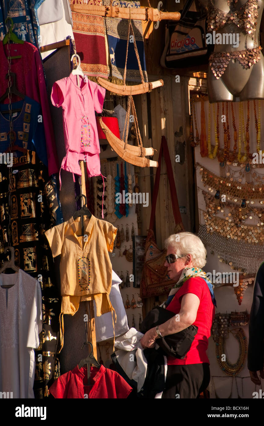 Egypt Kom Ombo village woman tourist red sweater gray hair looking at souvenirs Stock Photo