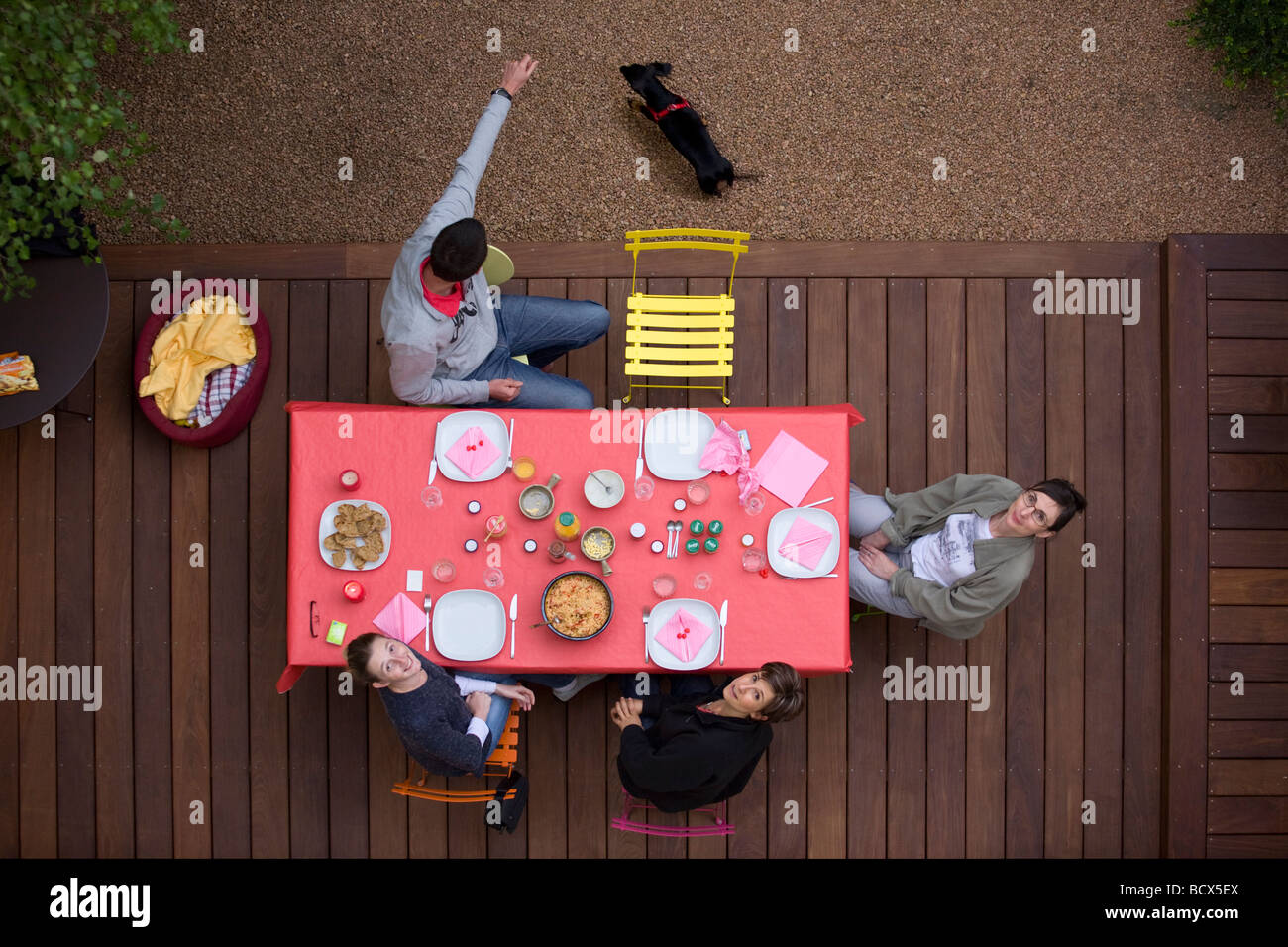 Friends having dinner on a terrace made out of ipé (Tabebuia sp). Dîner entre amis sur une terrasse en ipé (Tabebuia sp). Stock Photo