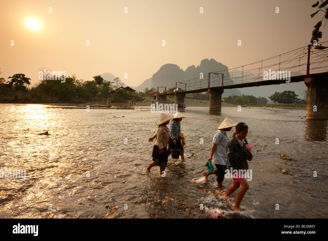women wading the Nam Song River, Vang Vieng, Laos Stock Photo