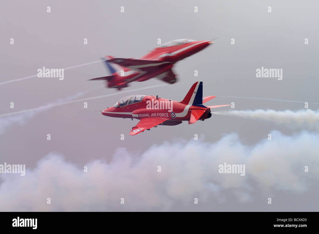 The Red Arrows Display Team Syncho Pair of Hawk T1 Trainer aeroplanes practice their dangerous opposition barrel rolls. Stock Photo