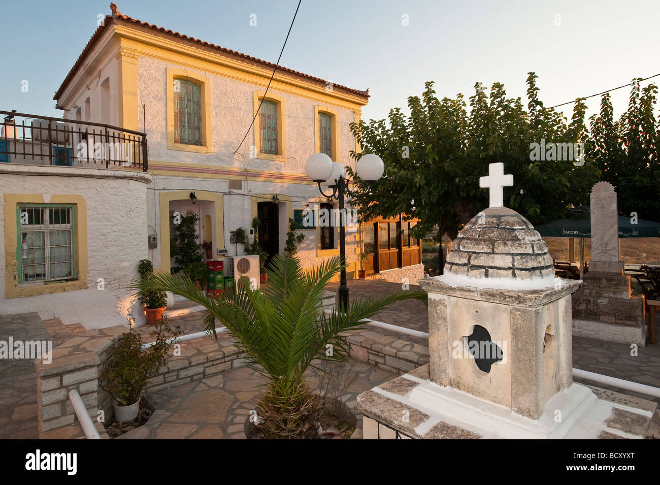 A small square with restaurantand old stone house in the village of Kontakeika on Samos island in Greece Stock Photo