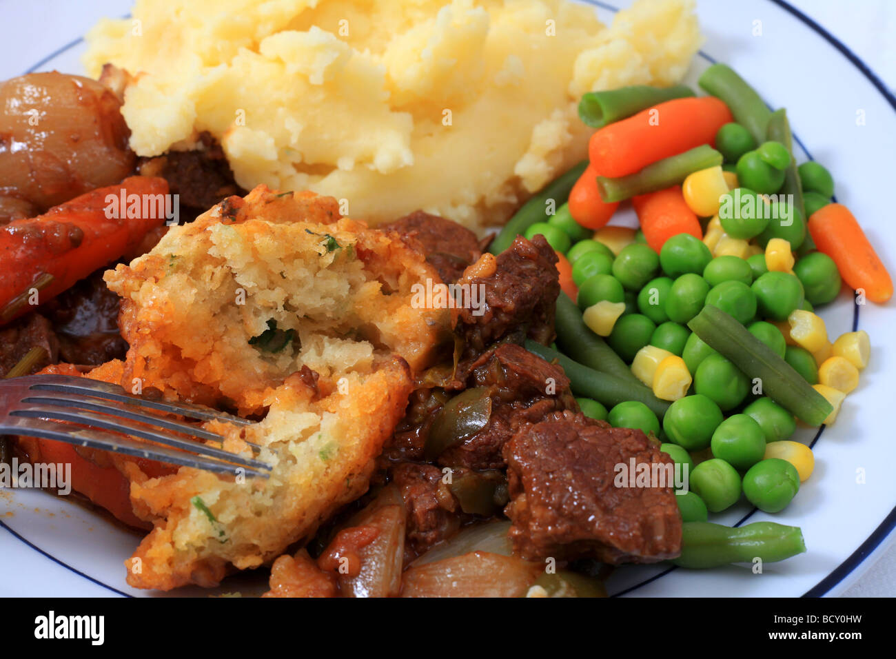 A traditional English parsley dumpling with beef stew potatoes and mixed vegetables Stock Photo