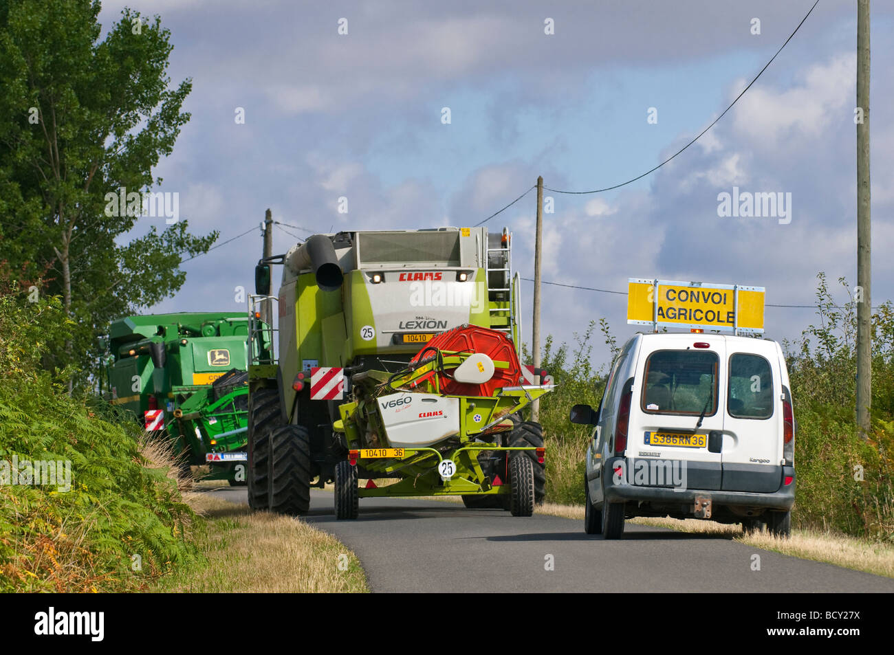 Claas and John Deere combine harvesters in convoy blocking public road, sud-Touraine, France. Stock Photo