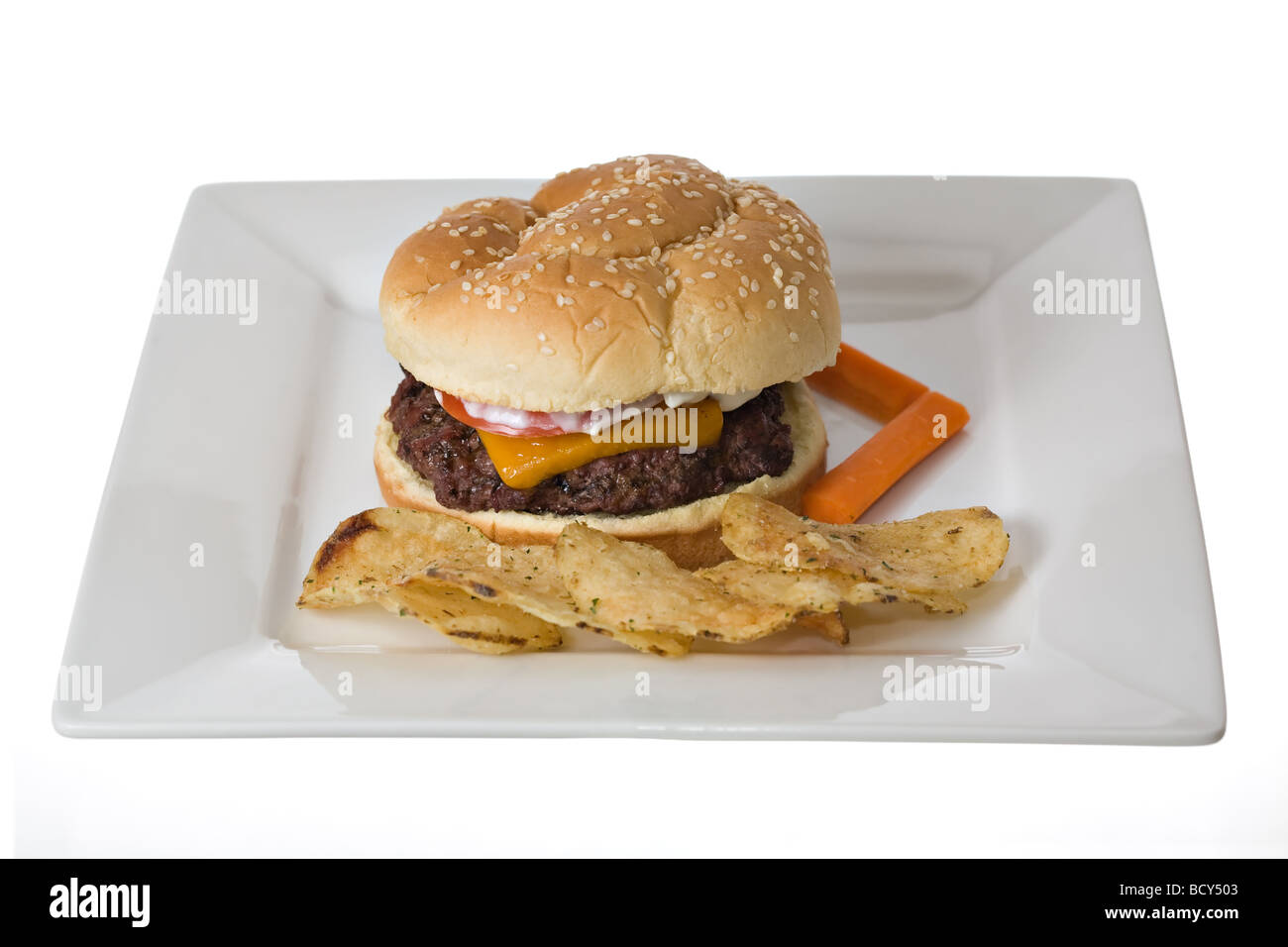 Cheesburger potato chips and two carrot sticks on white plate Carrots offer a little bit of balance to an otherwise fatty meal. Stock Photo