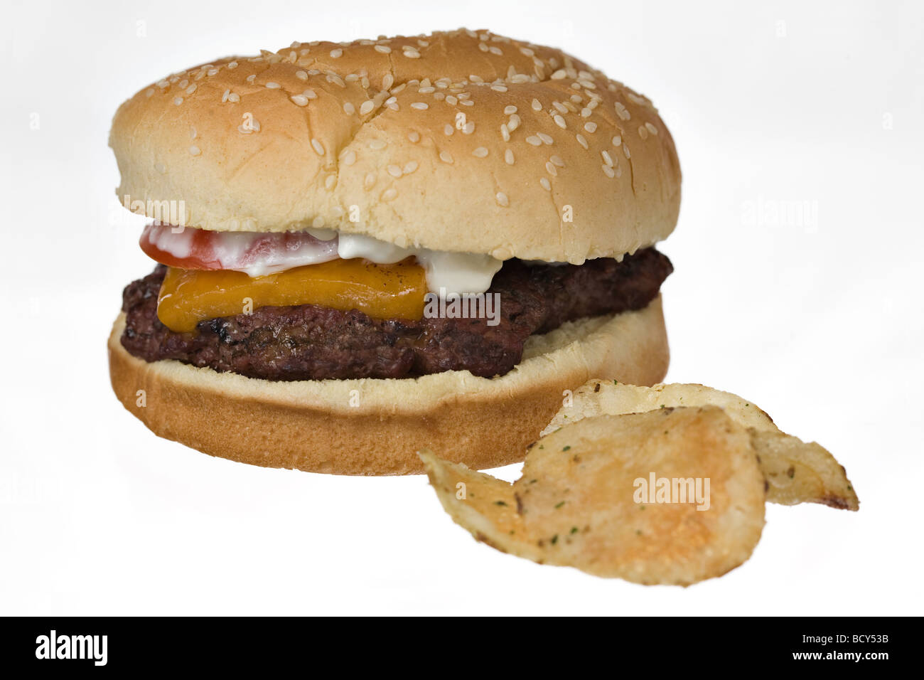 Hearty cheeseburger and potato chips on white background Stock Photo