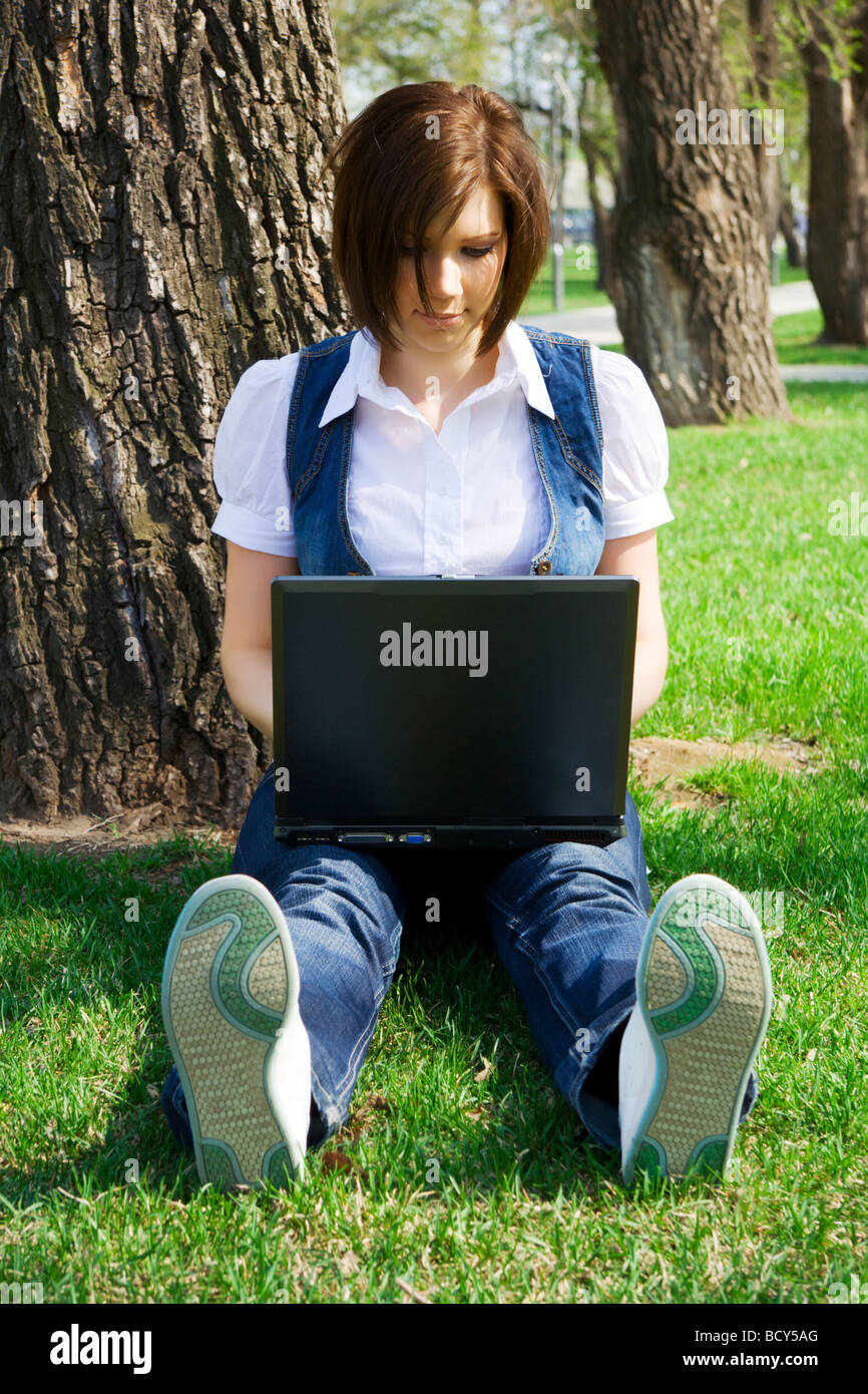 Young woman working on laptop in the city park Stock Photo - Alamy